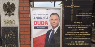 Brzesko. Plakat wyborczy na pomniku, obok tablicy upamiętniającej katastrofę smoleńską